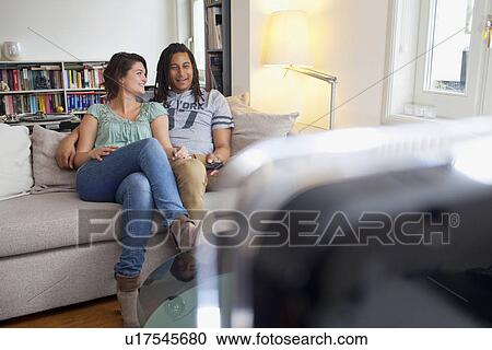 Couple relaxing together in living room View Large Photo Image Stock Image - Couple relaxing together in living room. Fotosearch