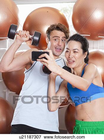 Couple taking picture together in gym View Large Photo Image Stock Photo - Couple taking picture together in gym. Fotosearch