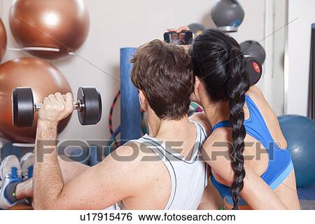 Stock Photograph - Couple taking picture together in gym. Fotosearch