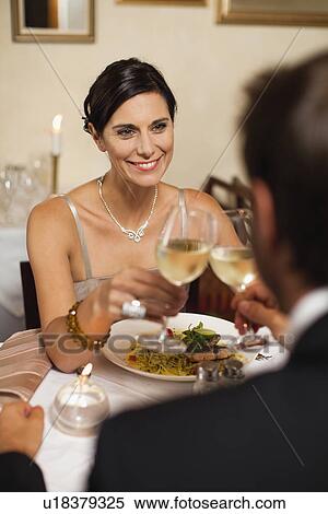 Stock Photography - Couple toasting each other in restaurant. Fotosearch