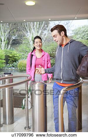 Stock Photograph - Couple walking through turnstile. Fotosearch