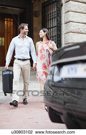 Stock Image - Couple walking to car on city street. Fotosearch