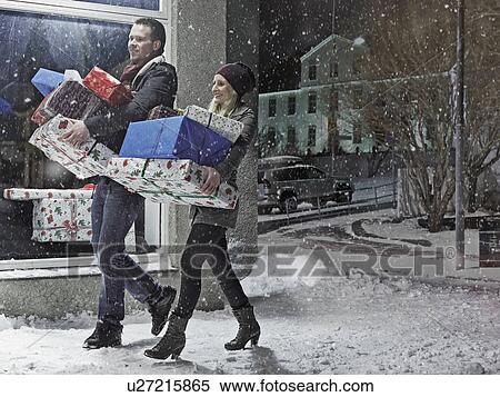 Stock Photography - Couple with Christmas gifts in snow. Fotosearch