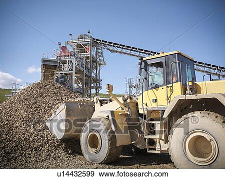 Digger scooping pile of stones in quarry View Large Photo Image Stock Photo - Digger scooping pile of stones in quarry. Fotosearch