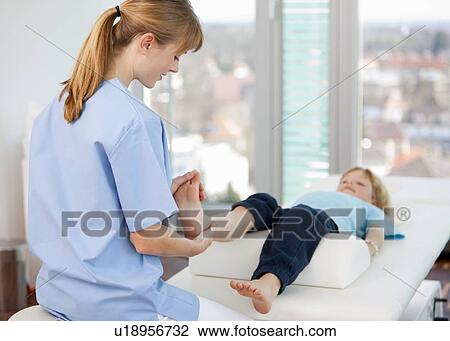 Doctor examining boys feet in office View Large Photo Image Stock Image - Doctor examining boys feet in office. Fotosearch