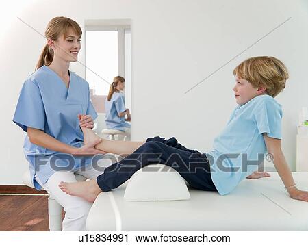 Doctor Examining Boys Feet In Office Doctor Examining Boys Feet In Office