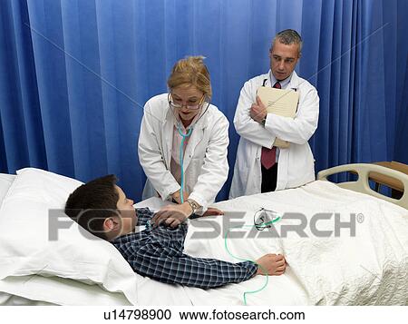 Doctor examining patient in hospital View Large Photo Image Stock Image - Doctor examining patient in hospital. Fotosearch