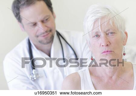 Stock Image - Doctor examining patient in office. Fotosearch