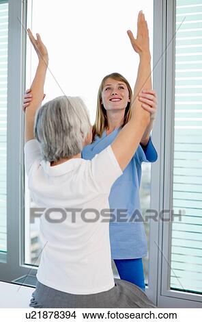 Picture - Doctor examining womans arms in office. Fotosearch