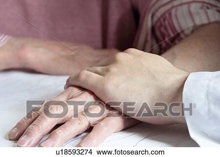 Doctor holding older womans hand View Large Photo Image Picture - Doctor holding older womans hand. Fotosearch