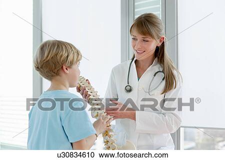 Doctor showing skeletal model to patient View Large Photo Image Stock Image - Doctor showing skeletal model to patient. Fotosearch