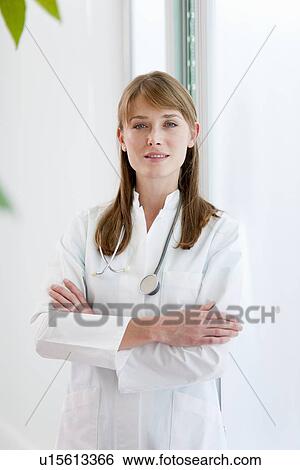Stock Photograph - Doctor standing with arms crossed. Fotosearch