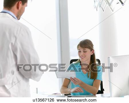 Stock Photograph - Doctor talking to receptionist in office. Fotosearch