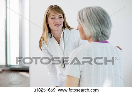 Stock Photo - Doctor talking to woman in office. Fotosearch
