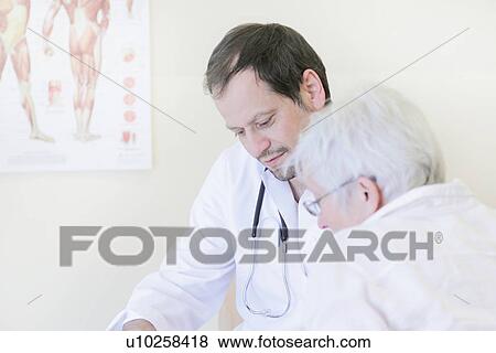 Stock Photo - Doctor talking with patient in office. Fotosearch