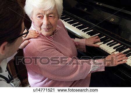Doctor watching older woman play piano View Large Photo Image Stock Image - Doctor watching older woman play piano. Fotosearch
