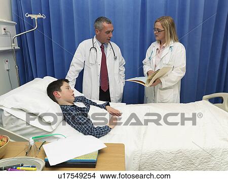 Picture - Doctors examining patient in hospital. Fotosearch