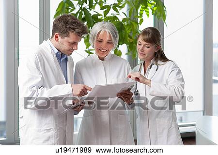 Doctors talking together in hospital View Large Photo Image Stock Photo - Doctors talking together in hospital. Fotosearch