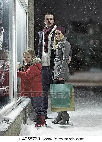 Stock Image - Family Christmas shopping in snow. Fotosearch