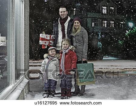Stock Photography - Family Christmas shopping in snow. Fotosearch