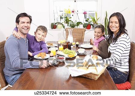 Picture - Family eating breakfast at table. Fotosearch
