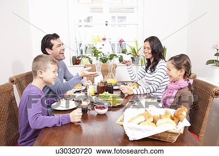Family eating breakfast at table View Large Photo Image Stock Image - Family eating breakfast at table. Fotosearch