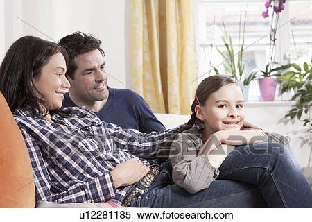 Family relaxing on sofa in living room View Large Photo Image Stock Photography - Family relaxing on sofa in living room. Fotosearch