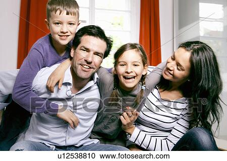 Family smiling together on bed View Large Photo Image Stock Image - Family smiling together on bed. Fotosearch