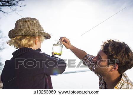 Father and son collecting jar of water View Large Photo Image Stock Photo - Father and son collecting jar of water. Fotosearch