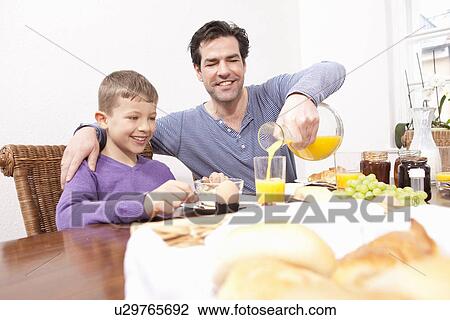 Stock Image - Father and son eating breakfast. Fotosearch