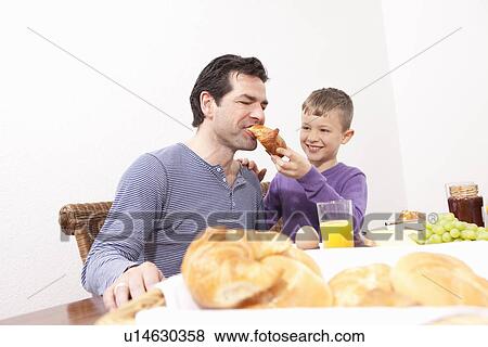 Stock Photo - Father and son eating breakfast. Fotosearch