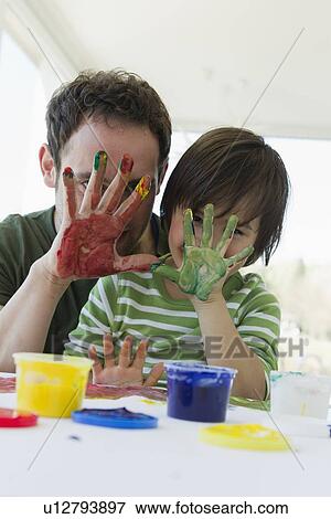 Stock Photo - Father and son finger painting together. Fotosearch