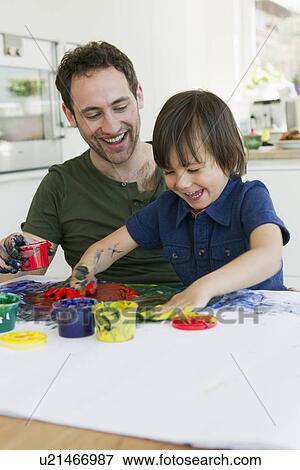 Father and son finger painting together View Large Photo Image Stock Photo - Father and son finger painting together. Fotosearch