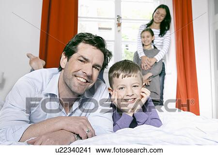 Father and son laying on bed View Large Photo Image Stock Image - Father and son laying on bed. Fotosearch