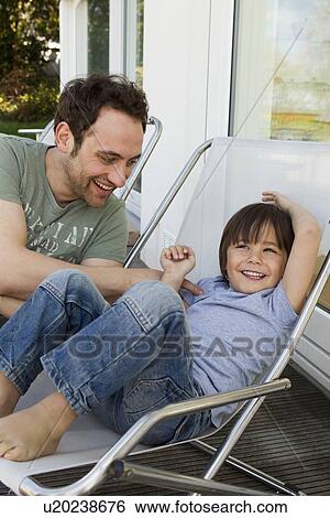 Father and son playing in deck chairs View Large Photo Image Stock Photograph - Father and son playing in deck chairs. Fotosearch