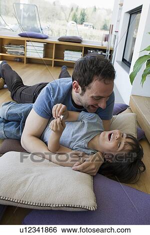 Father and son playing in living room View Large Photo Image Stock Photograph - Father and son playing in living room. Fotosearch