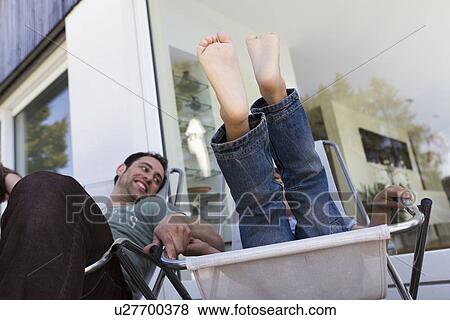 Stock Photo - Father and son relaxing in deck chairs. Fotosearch