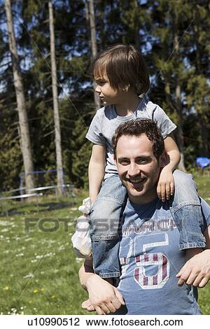 Father carrying son on shoulders View Large Photo Image Stock Image - Father carrying son on shoulders. Fotosearch