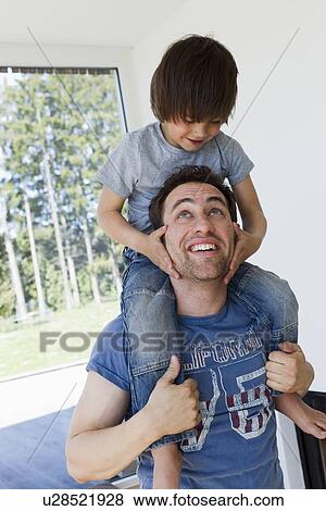 Stock Photo - Father carrying son on shoulders. Fotosearch