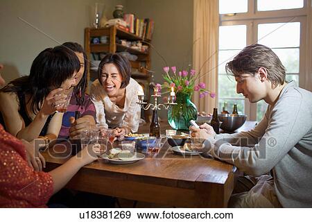 Friends laughing at dinner table View Large Photo Image Stock Photo - Friends laughing at dinner table. Fotosearch