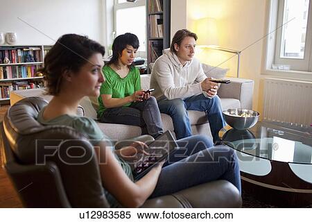 Friends relaxing together in living room View Large Photo Image Stock Photography - Friends relaxing together in living room. Fotosearch