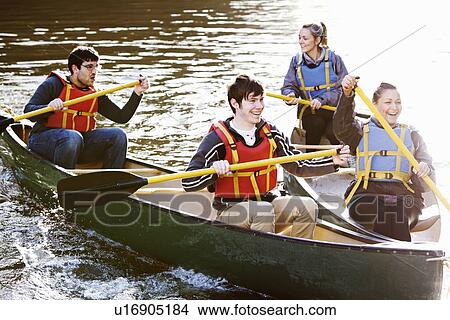 Picture - Friends rowing canoes on still lake. Fotosearch