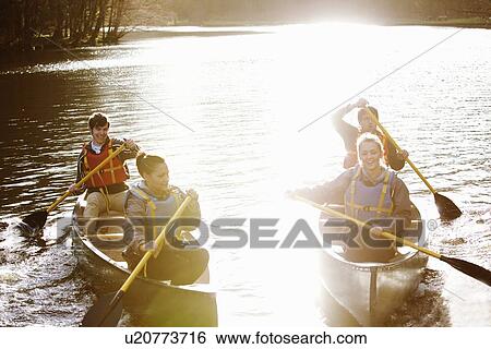 Friends rowing canoes on still lake View Large Photo Image Stock Photograph - Friends rowing canoes on still lake. Fotosearch