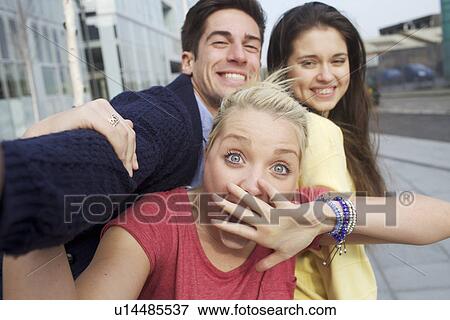 Stock Photo - Friends smiling together on city street. Fotosearch