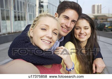 Stock Photo - Friends smiling together on city street. Fotosearch