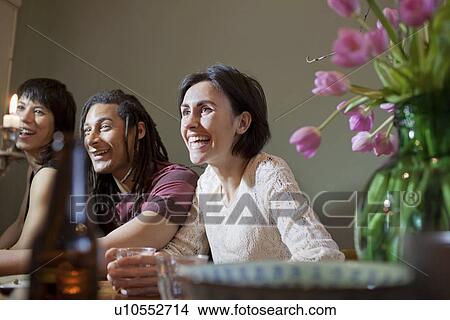 Friends talking at dinner table View Large Photo Image Picture - Friends talking at dinner table. Fotosearch