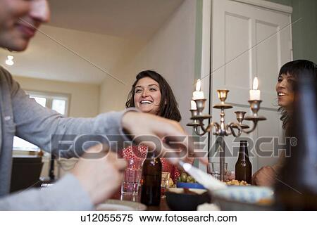 Friends talking at dinner table View Large Photo Image Stock Photography - Friends talking at dinner table. Fotosearch