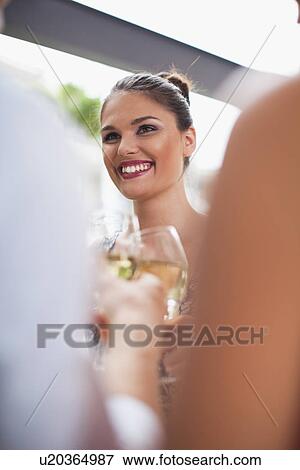 Stock Photo - Friends toasting each other at party. Fotosearch