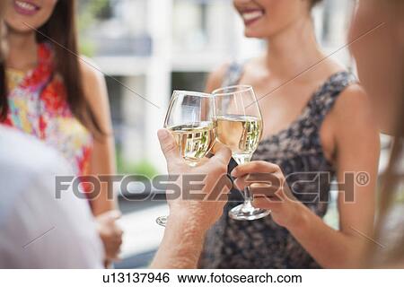 Stock Photograph - Friends toasting each other at party. Fotosearch