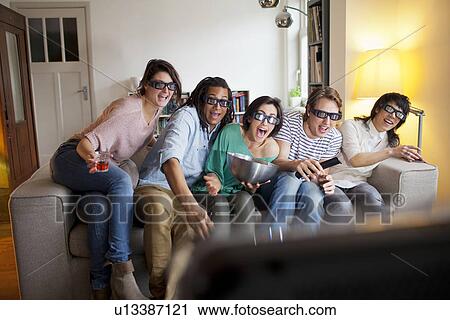 Friends watching 3D movie in living room View Large Photo Image Stock Image - Friends watching 3D movie in living room. Fotosearch